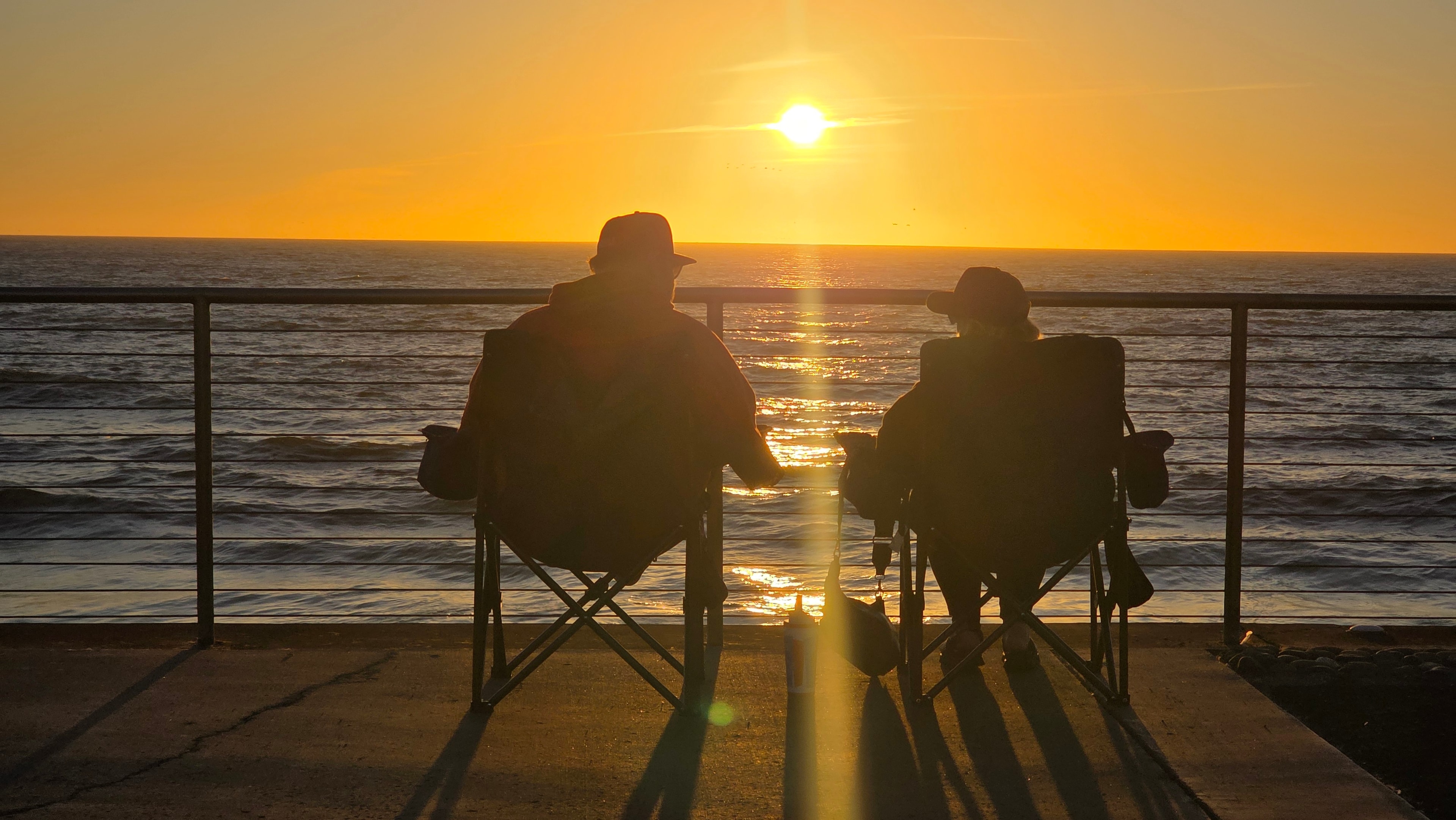People observing waves from Pacifica's black sand beach